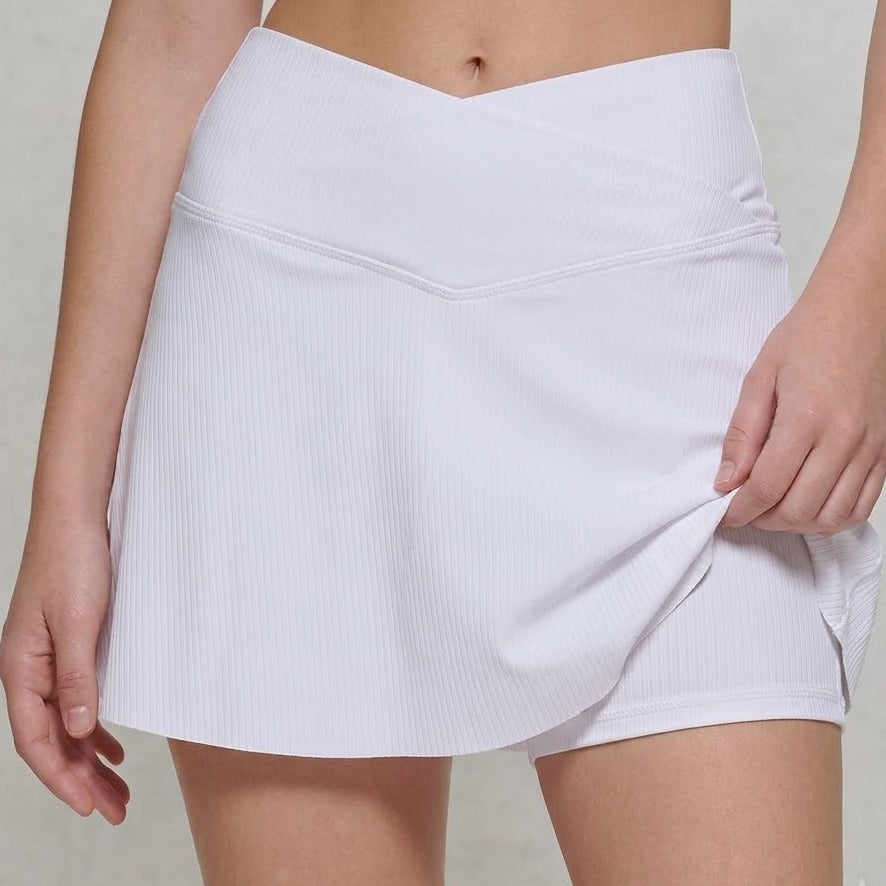 White skirt worn by a person on a neutral background