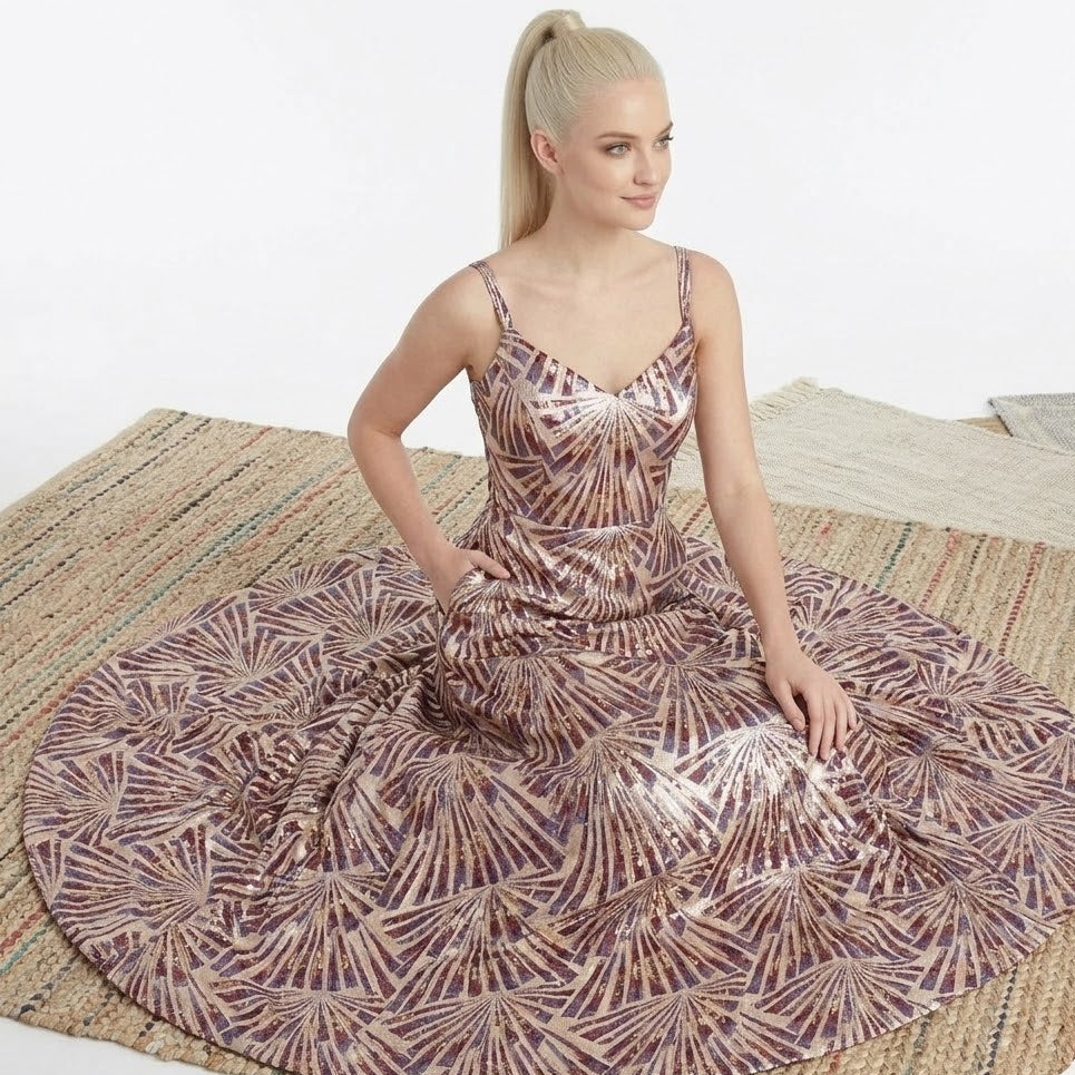 Woman in a patterned dress sitting on a textured surface